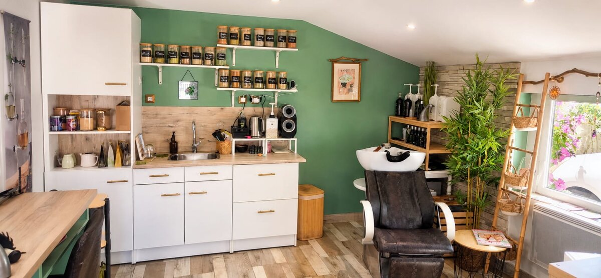Bac à shampoing du salon Myst Hair, bocaux de plantes et mur vert